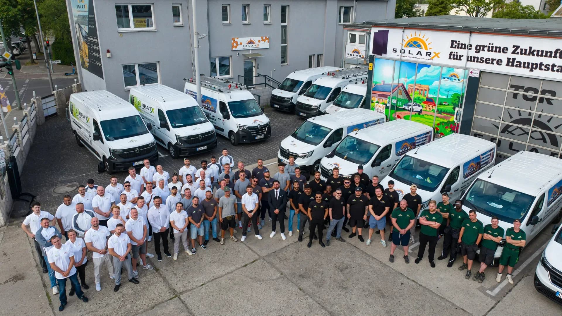 Unser Team der SolarX GmbH vor den eigenen Servicefahrzeugen auf dem Hof in der Wittestraße in Berlin-Reinickendorf Die SolarX- und HeatX-Mannschaft auf dem Firmenhof in Berlin