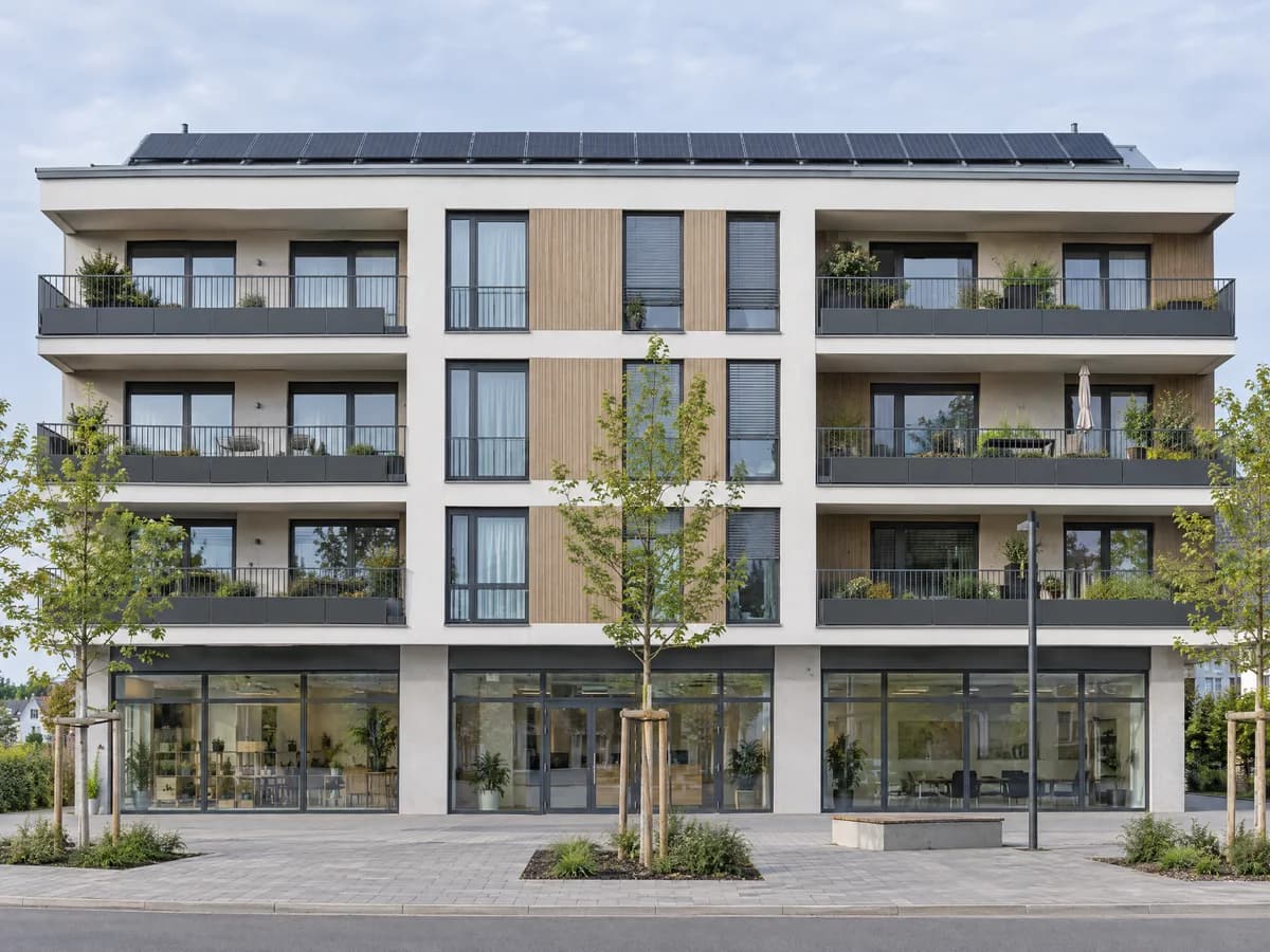 SolarX – Wohn- und Geschäftshaus mit Photovoltaik auf dem Flachdach Gebäude mit Ladenzeile im Erdgeschoss und Wohnungen darüber, Solarmodule auf dem Flachdach