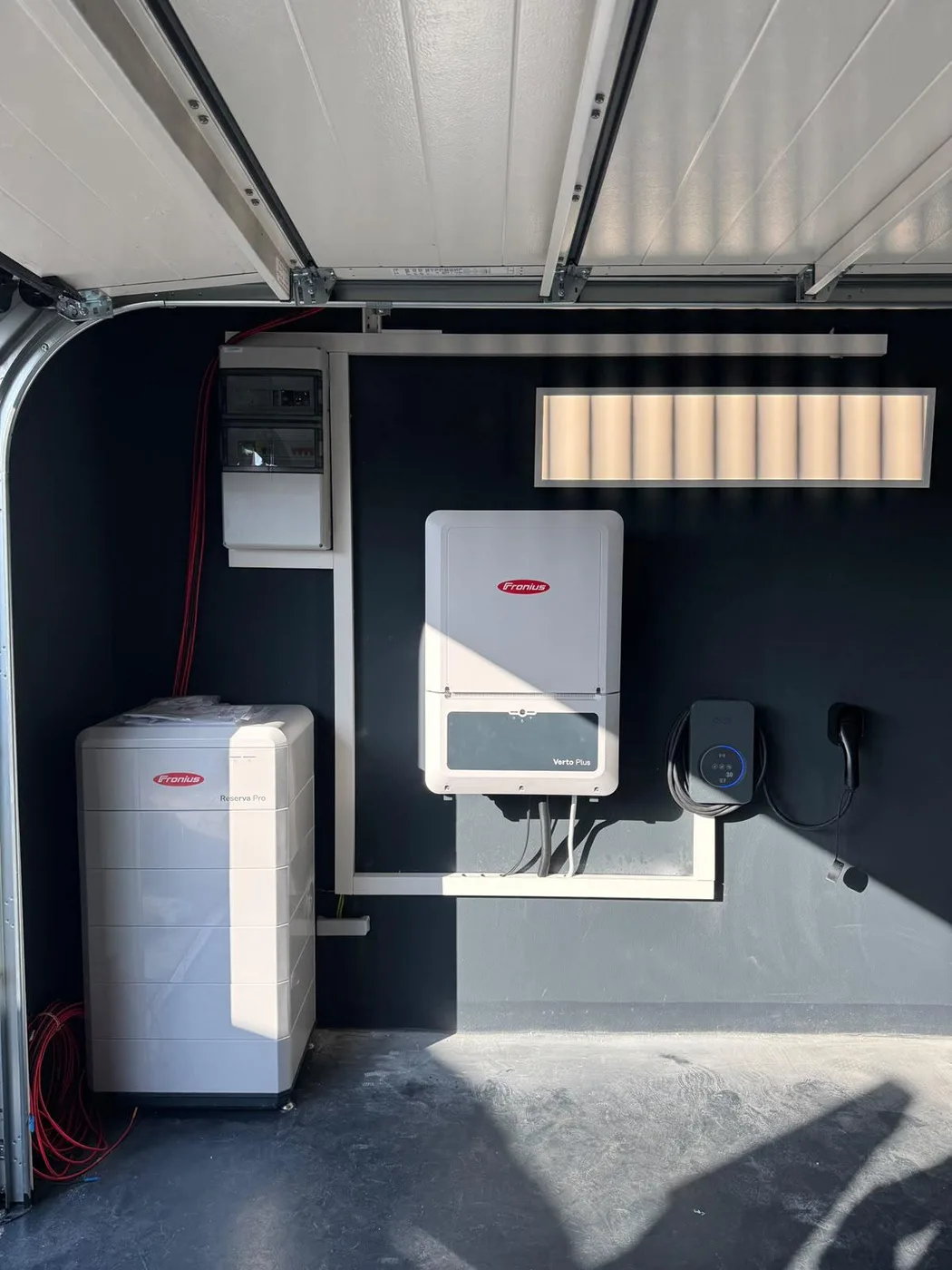 Photovoltaik-Referenz SolarX – Speicher und Wechselrichter in der Garage SolarX Referenz: Speicher und Wechselrichter in einer Garage, daneben das geschlossene Garagentor