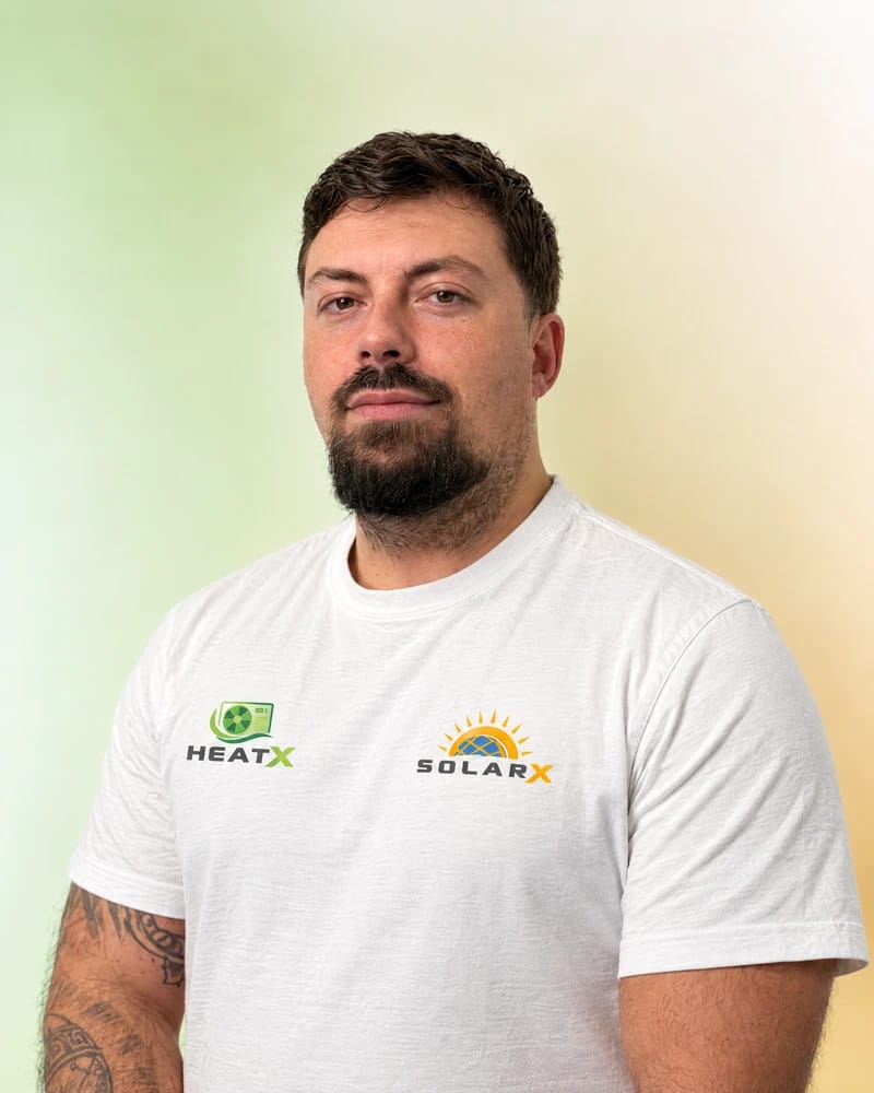 Nico – Fachberater von SolarX Nico im weißen Teamshirt mit HeatX- und SolarX-Logo vor dem grün-goldenen Porträthintergrund.