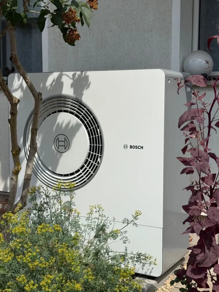HeatX – Bosch Wärmepumpen-Außeneinheit an der Hausfassade Außeneinheit einer Luft-Wasser-Wärmepumpe an einer Hauswand